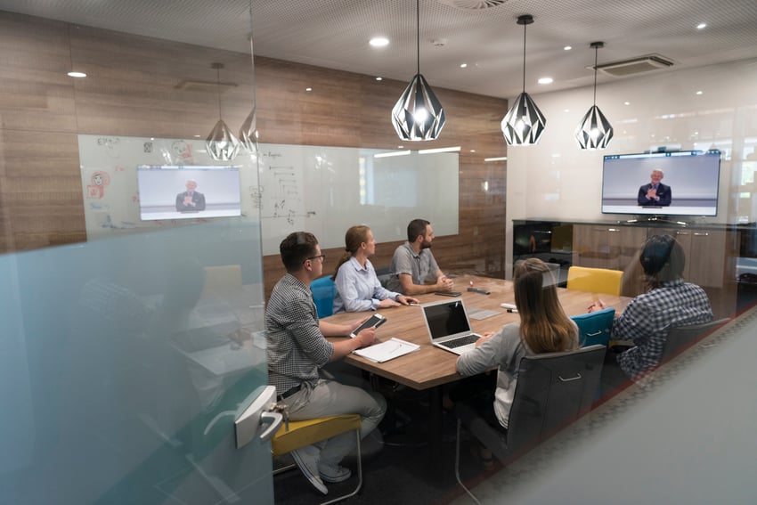 Team meeting occurring in a conference room with someone dialed in
