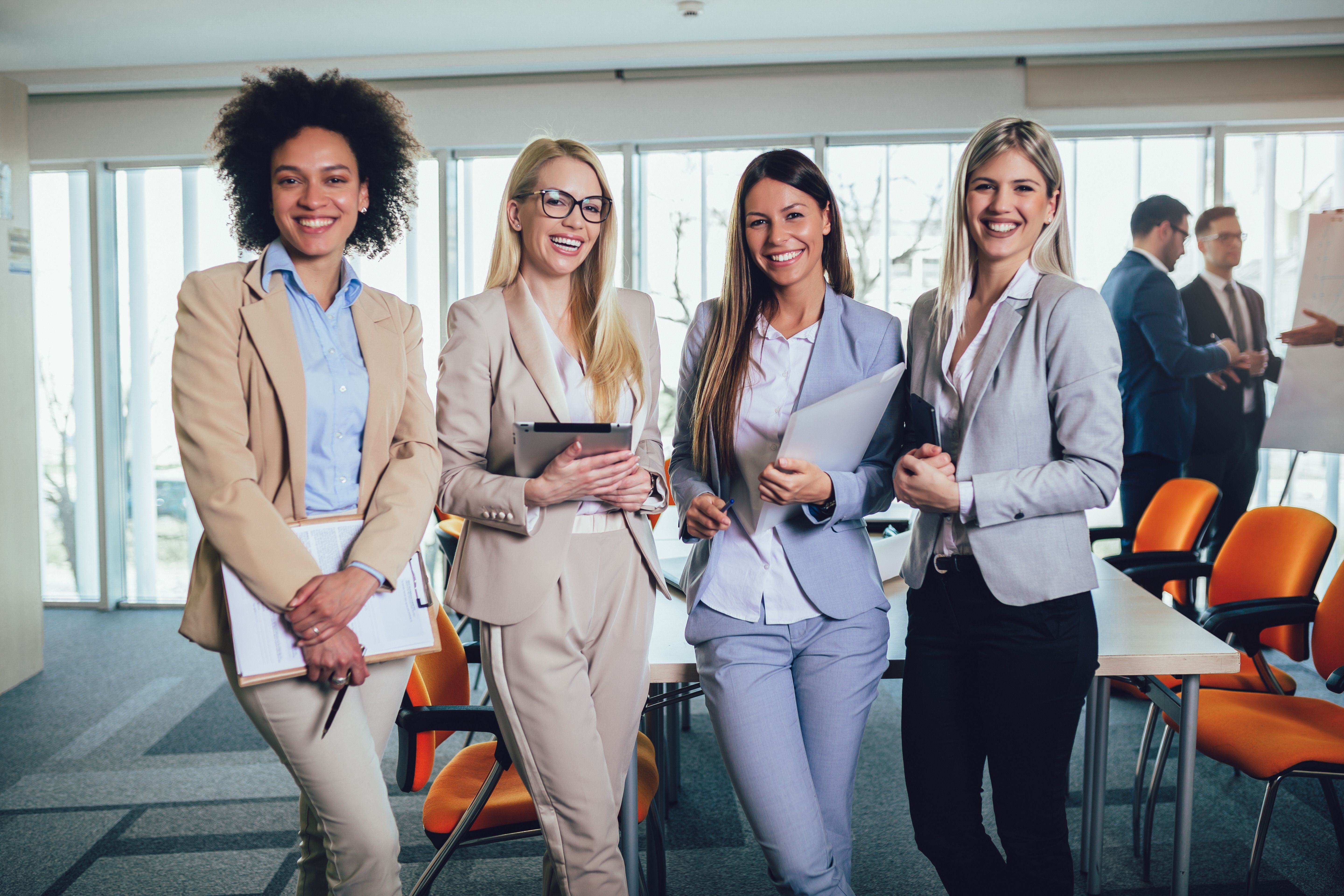 Group of 4 women smiling in an office setting