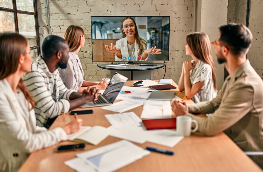 Team meeting occurring in a conference room with someone dialed in