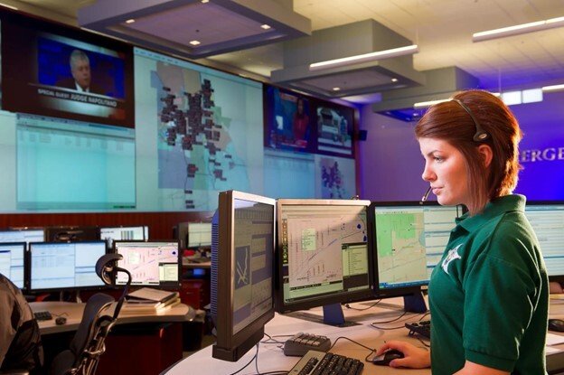 control room operator working on a desktop in a control room