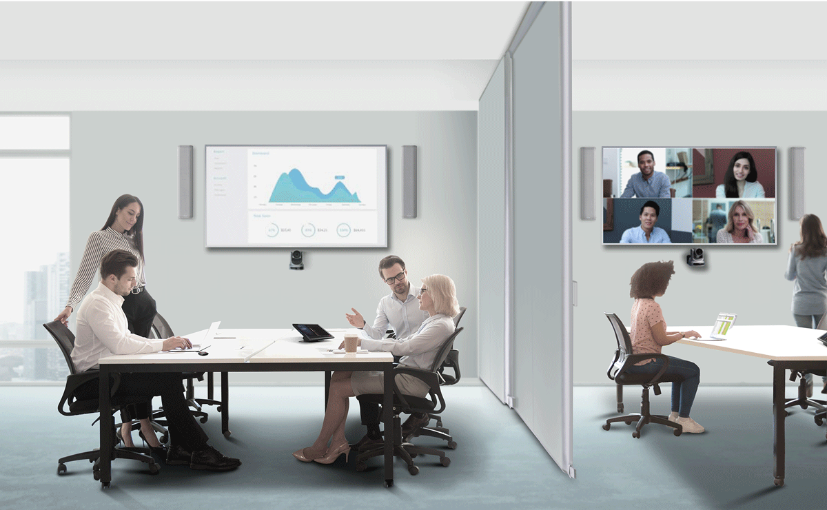 Two rooms divided by a adjustable wall with people inside. Each room has an undemented A/V system featuring Q-SYS peripherals